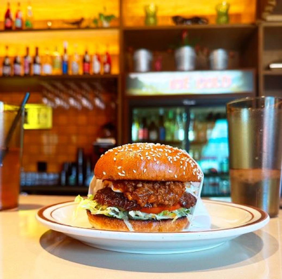A Winnipeg Fat Boy Burger on a plate set on the counter.