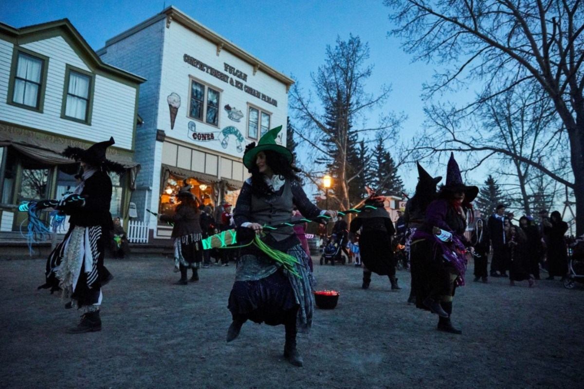 Witches in costume gather outside Sweet Shoppe for Ghouls' Night Out event.