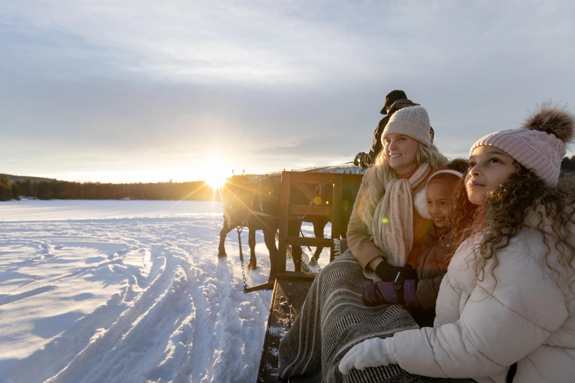 A family enjoying themselves on a winter sleigh ride as the sun goes down near Diamond Valley