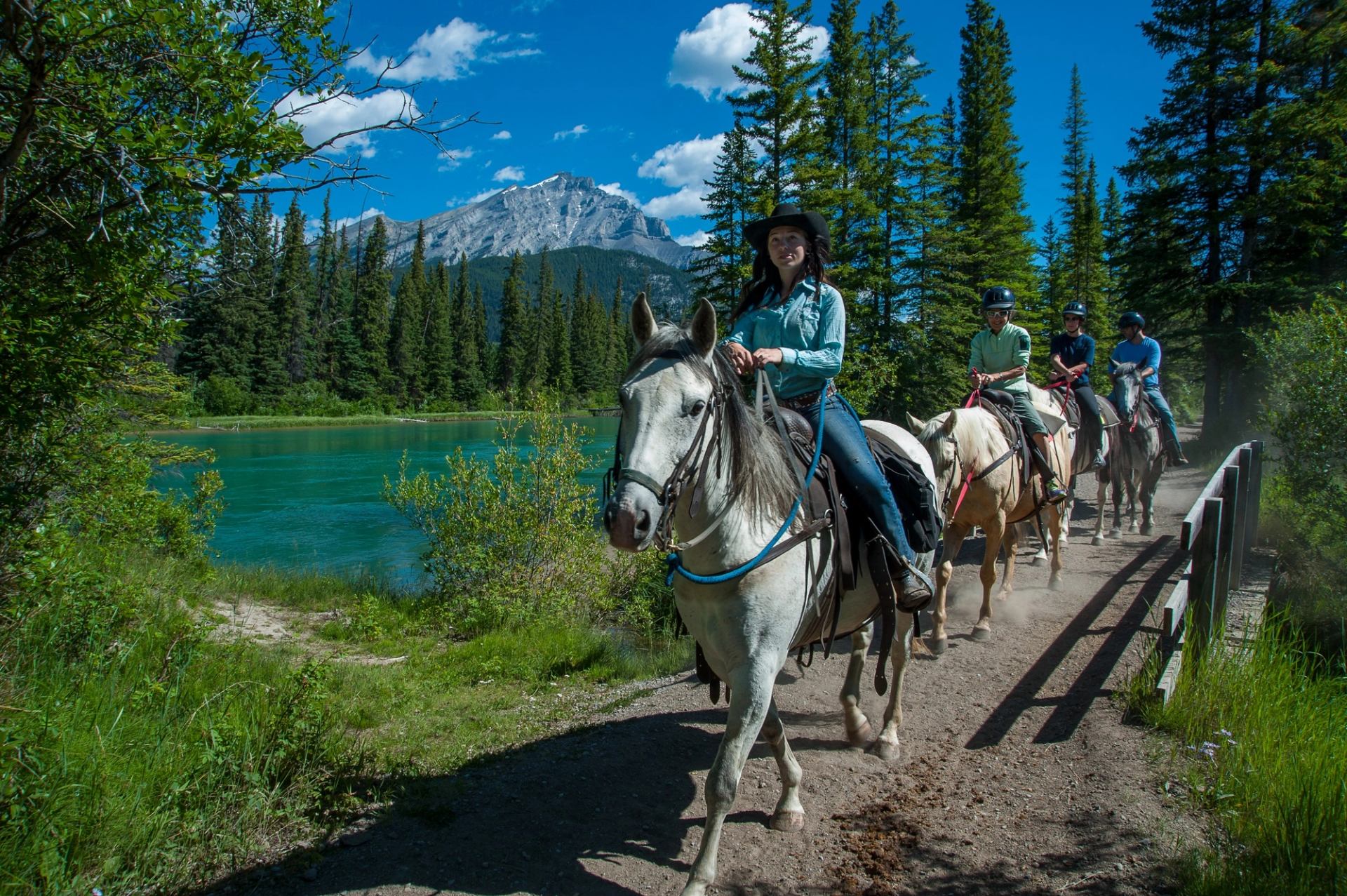People riding on horses on a trail.