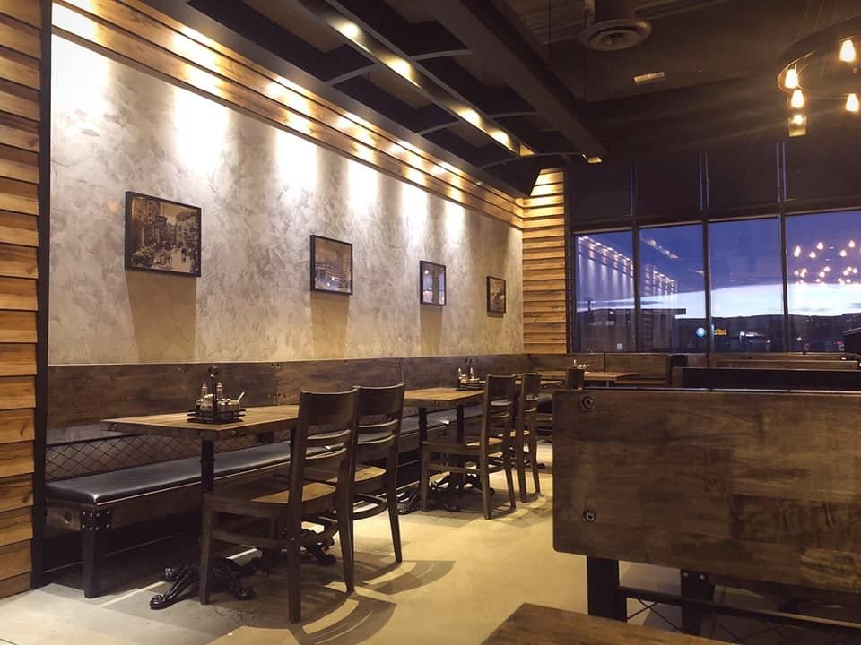 Cafe 100% dining area with wooden booths, tables, chairs, and large window.