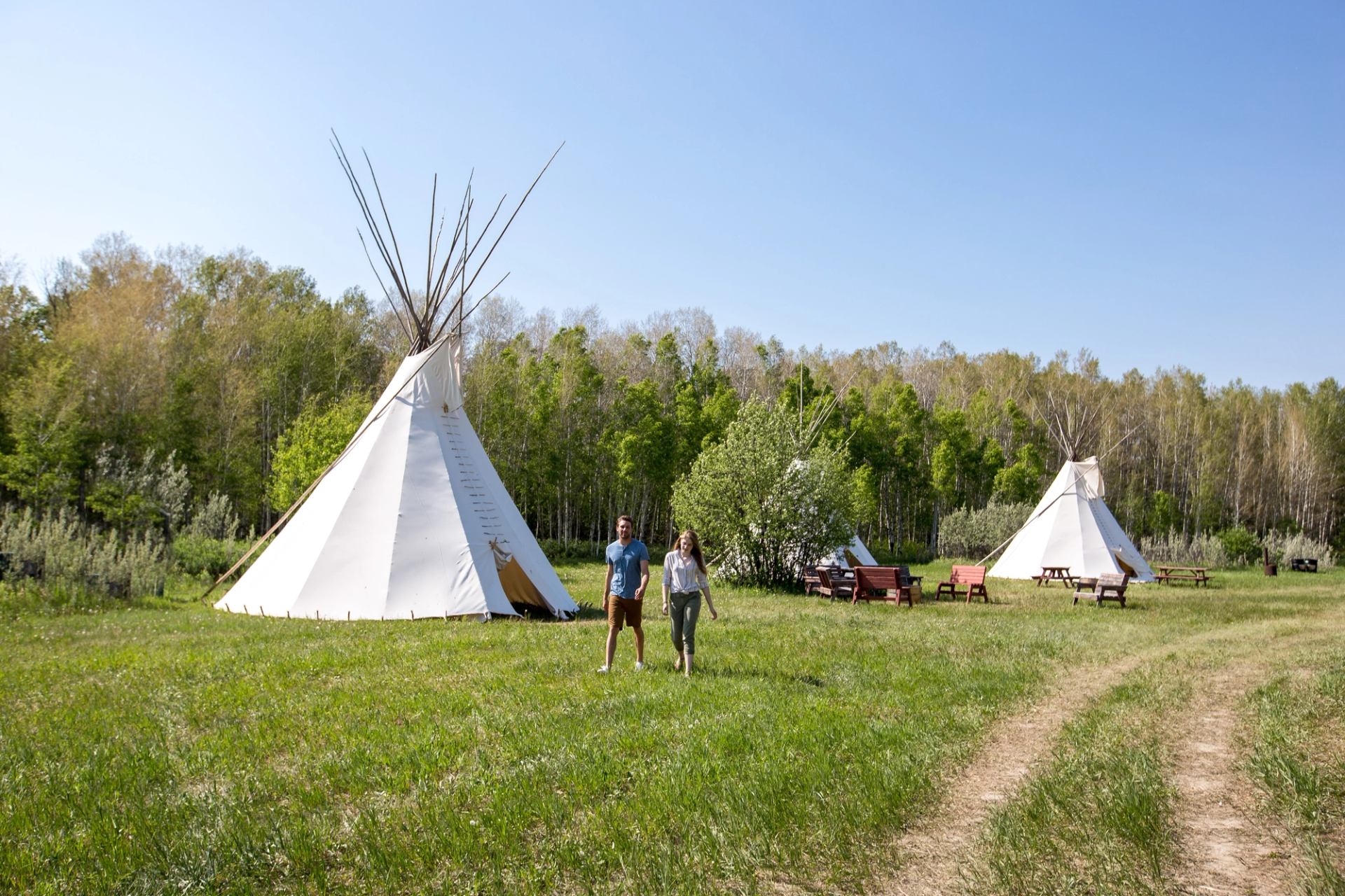 People exploring Tipi Village at Blackfoot Crossing Historical Park.
