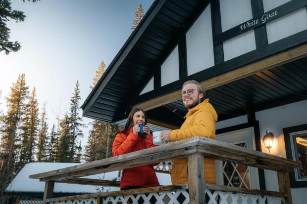 Couple enjoying coffee in front of Expanse Cottages cabin.