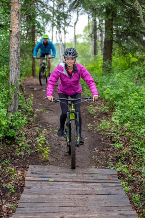 People mountain biking on trail at Nitehawks bike park