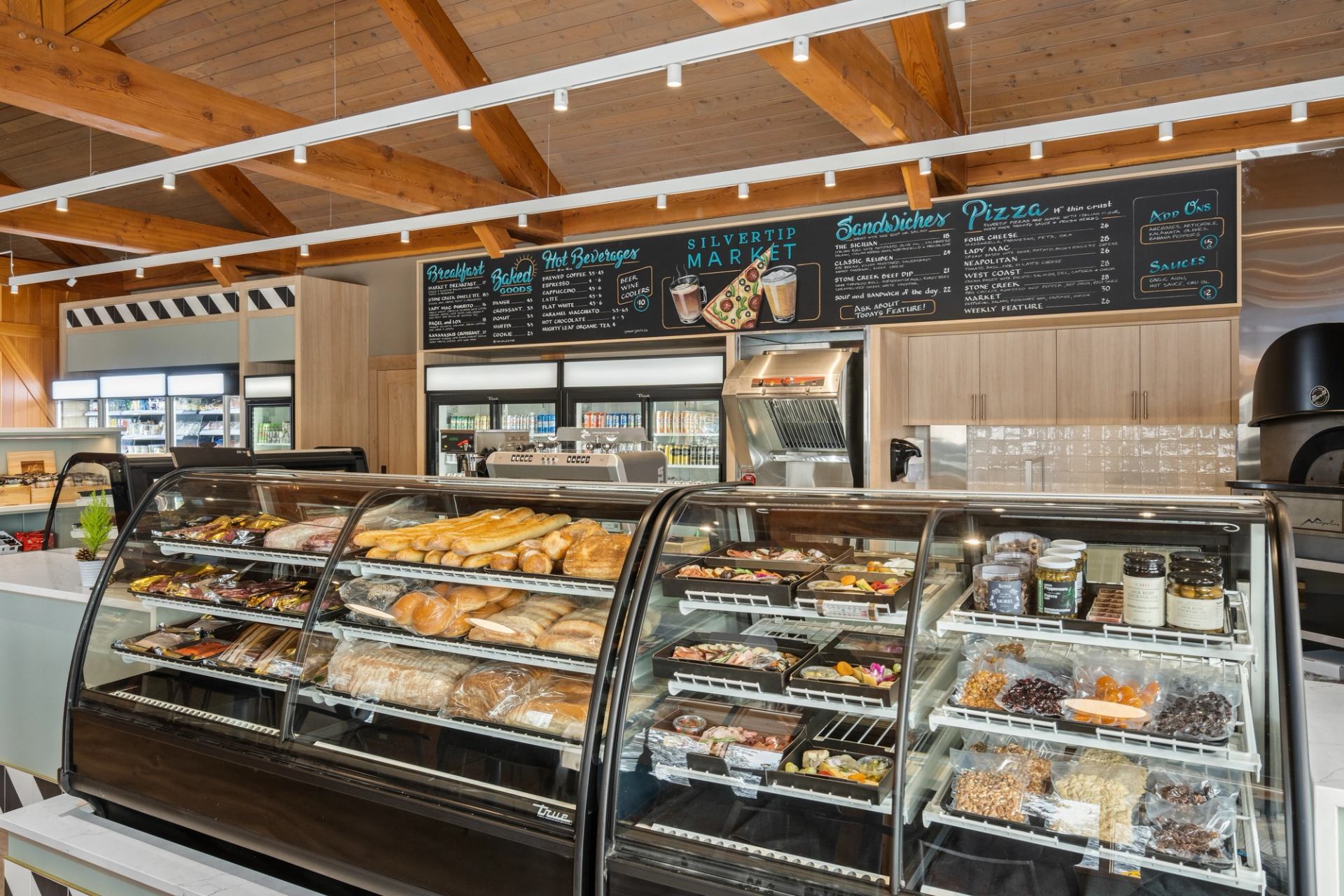 A deli display filled with breads, salads, cheeses, and ready-made meals.