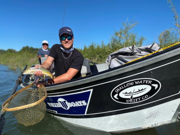 A man on a boat showing the fish he just caught.