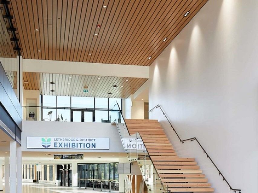 Library lobby with wood ceiling, staircase, and exhibition signage.