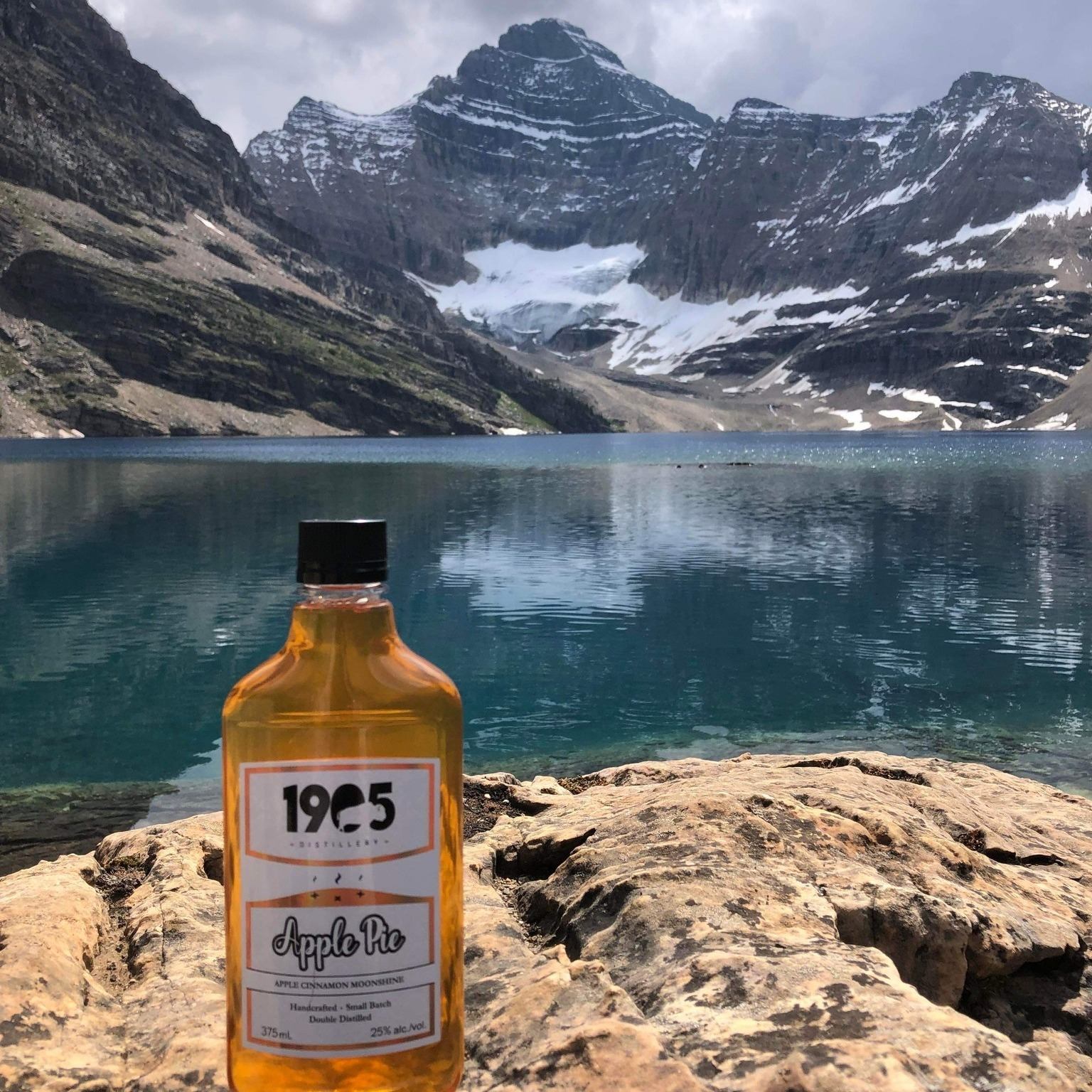 1905 Apple Pie Moonshine on a rock with the Three Sisters in the background.
