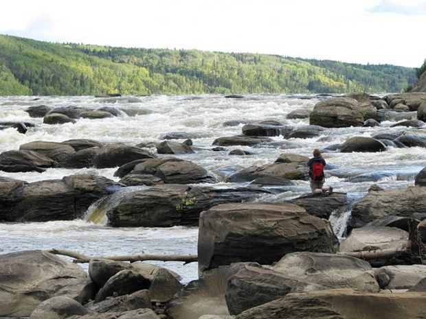 Person taking a photo at the Athabasca River Concretions in Alberta.