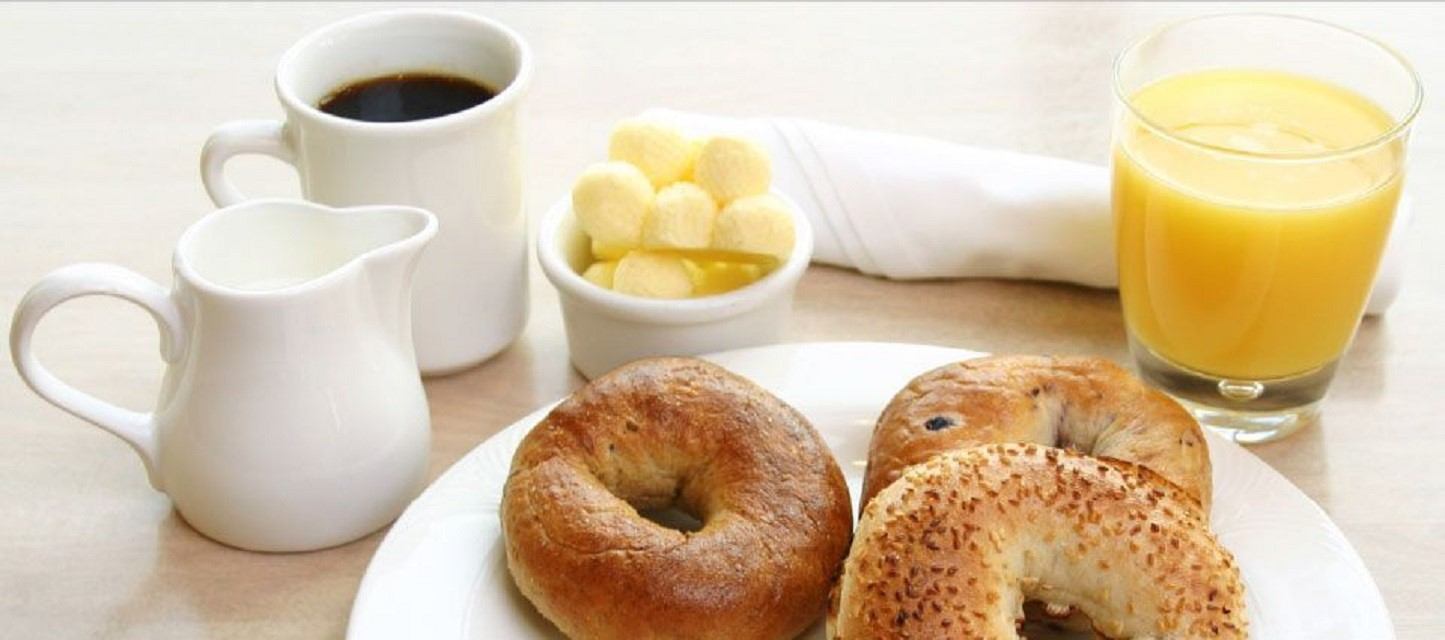 Breakfast plate with bagels, coffee, orange juice, and butter.