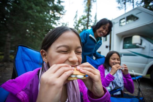 Family eating outdoors while RV camping at Whistlers Campground in Jasper National Park.