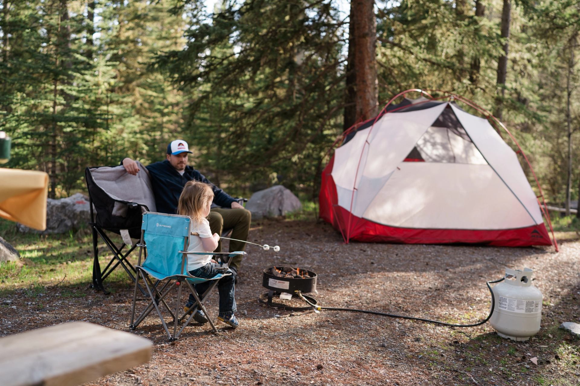 Man and toddler roasting marshmallows over a propane fire at burnt timber PRA