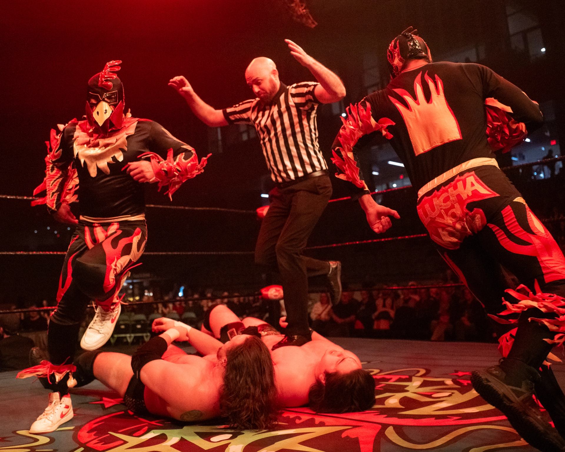 Chicken wrestlers dance around the ring while the ref runs over the competition.