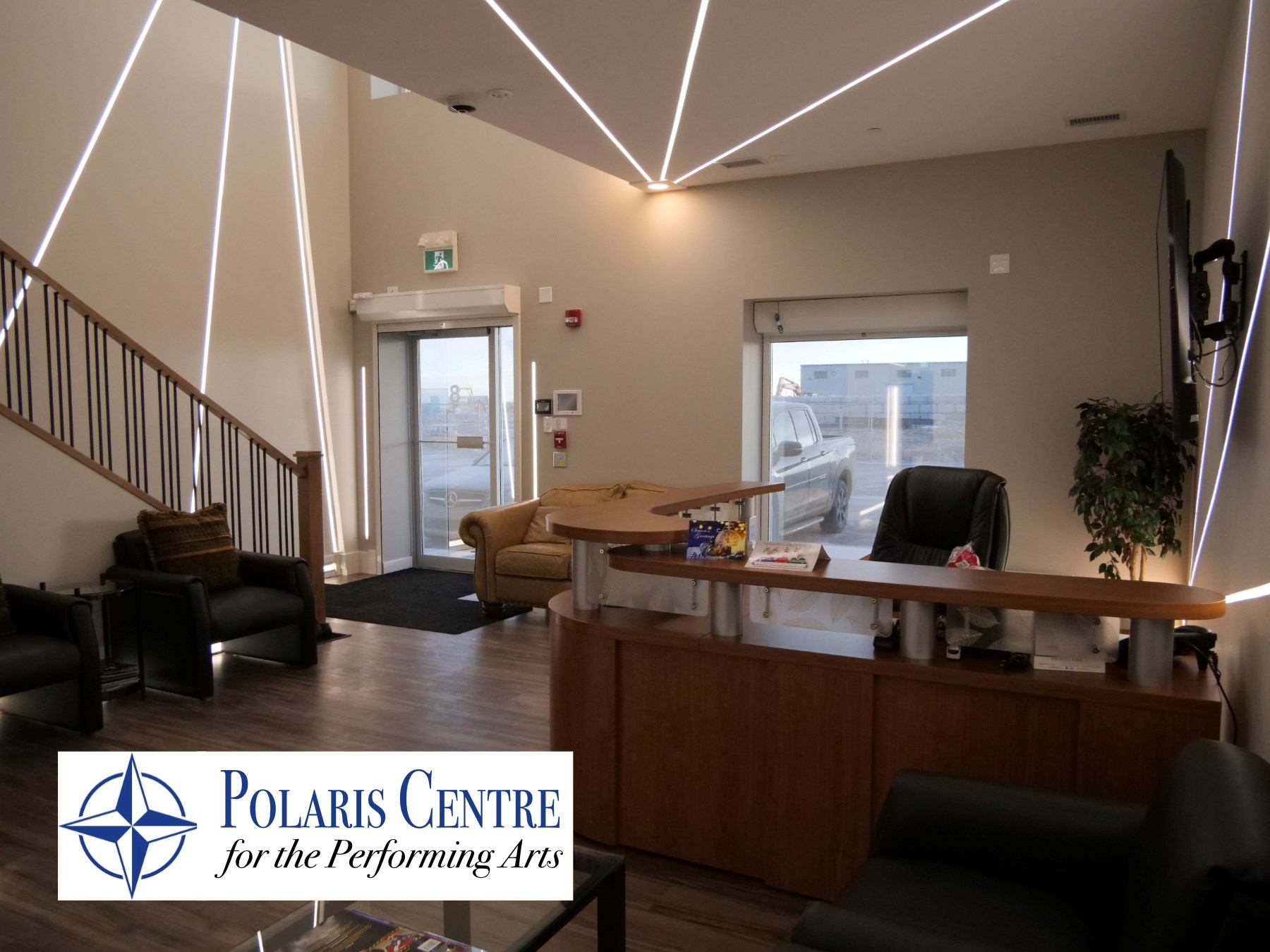 Lobby area with chairs, desk, and staircase at Polaris Centre for the Performing Arts.
