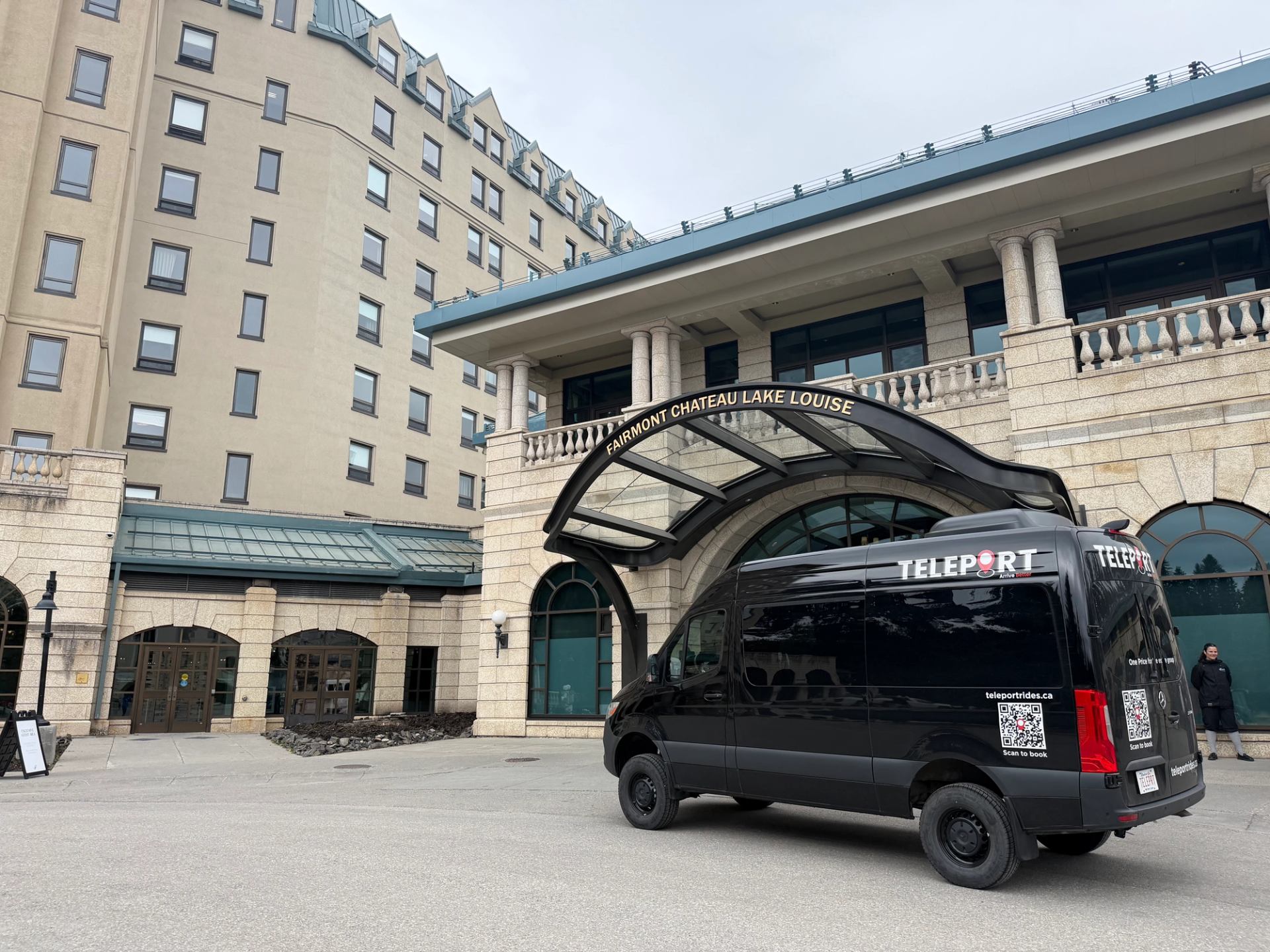 Black Teleport van parked outside Fairmont Chateau Lake Louise hotel entrance.
