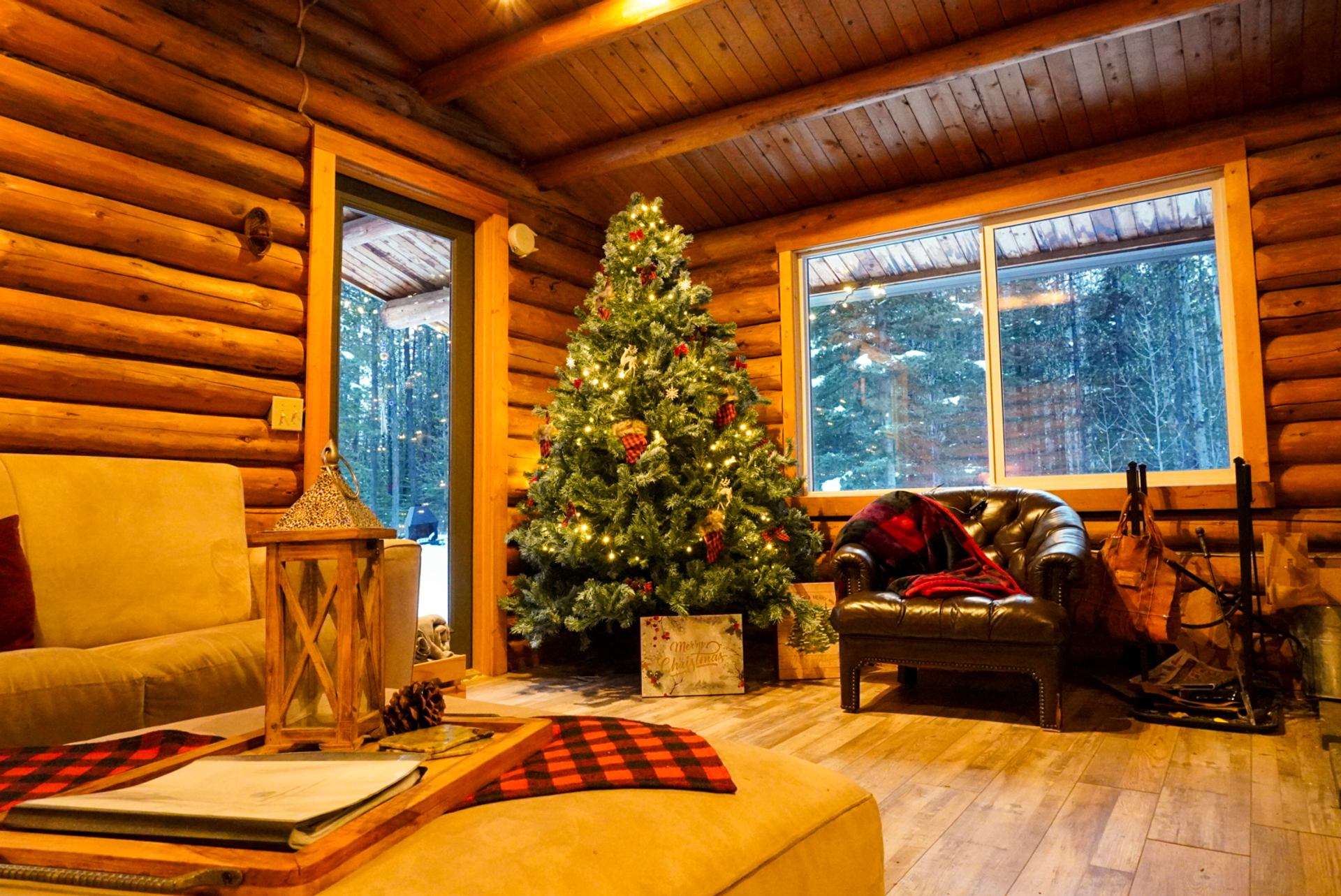 Cozy log cabin interior with a decorated Christmas tree at Trembling Aspen Retreat.