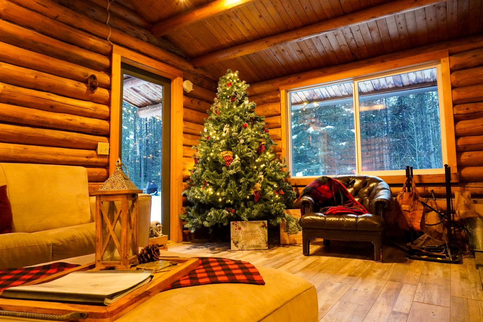 Cozy log cabin interior with a decorated Christmas tree at Trembling Aspen Retreat.