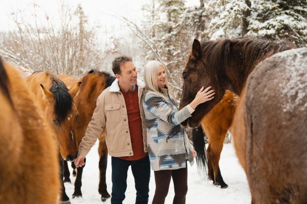 Couple petting horses at Anchor D Guiding & Outfitting