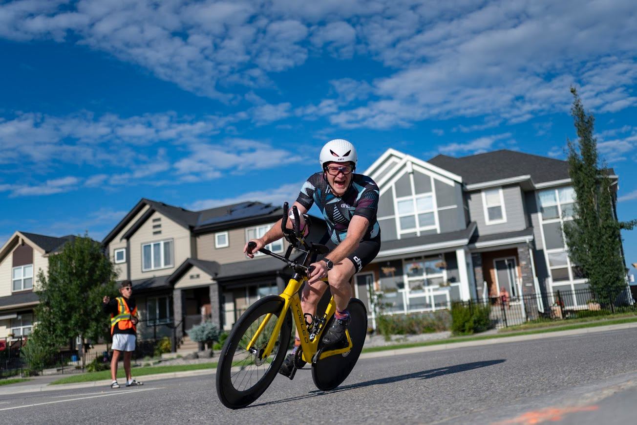 Cyclist speeding through a residential street during the Lake Chaparral Triathlon.
