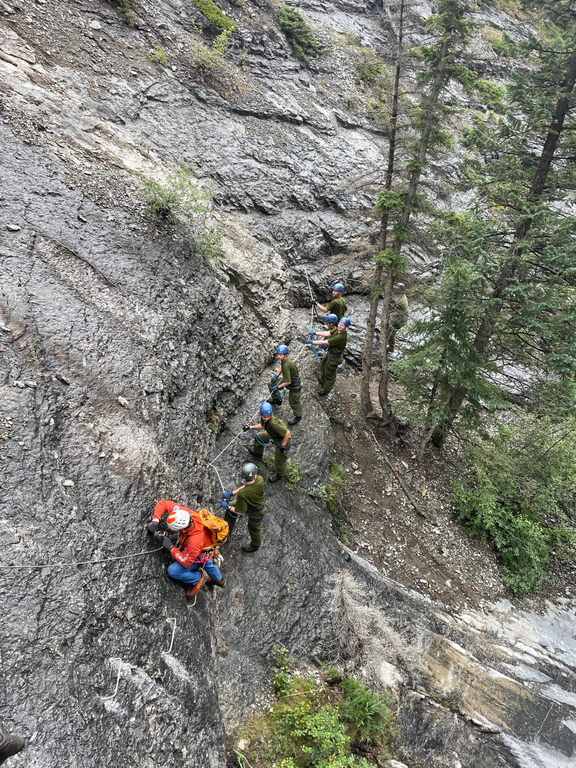 Group of hikers (or climbers) walking together on a trail (or climbing) in a natural outdoor setting.