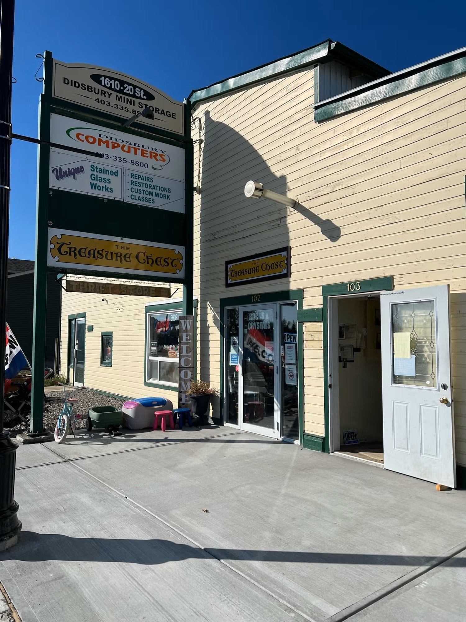Exterior of The Treasure Chest store with open door and signage on a sunny day.