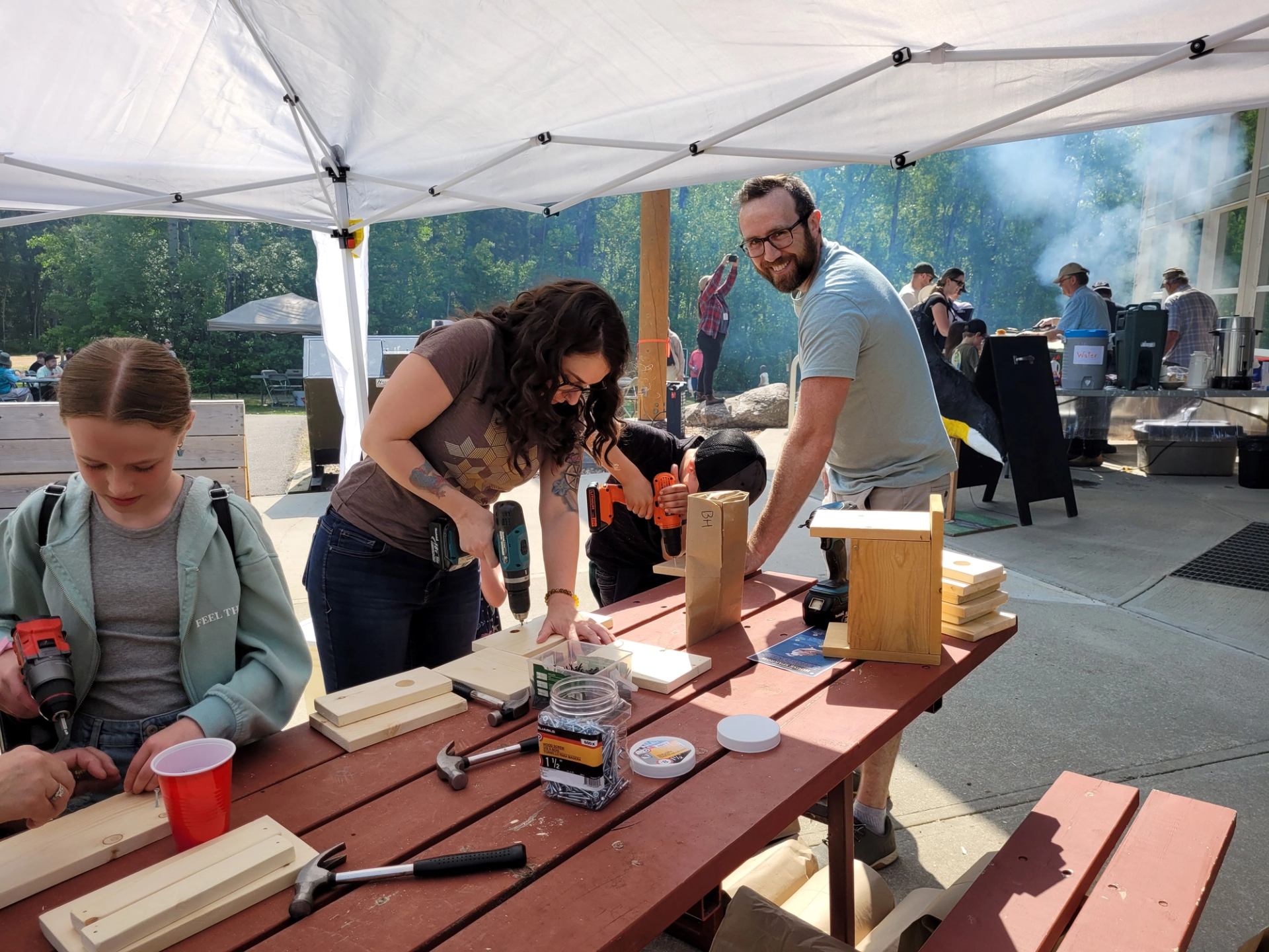 Adults and children working together on simple woodworking projects at the Annual Songbird Festival.