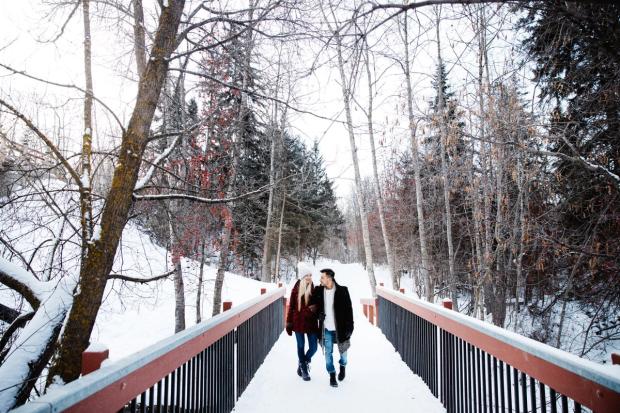 A man and woman walk along a Mill Creek Ravine bridge on a winter day.