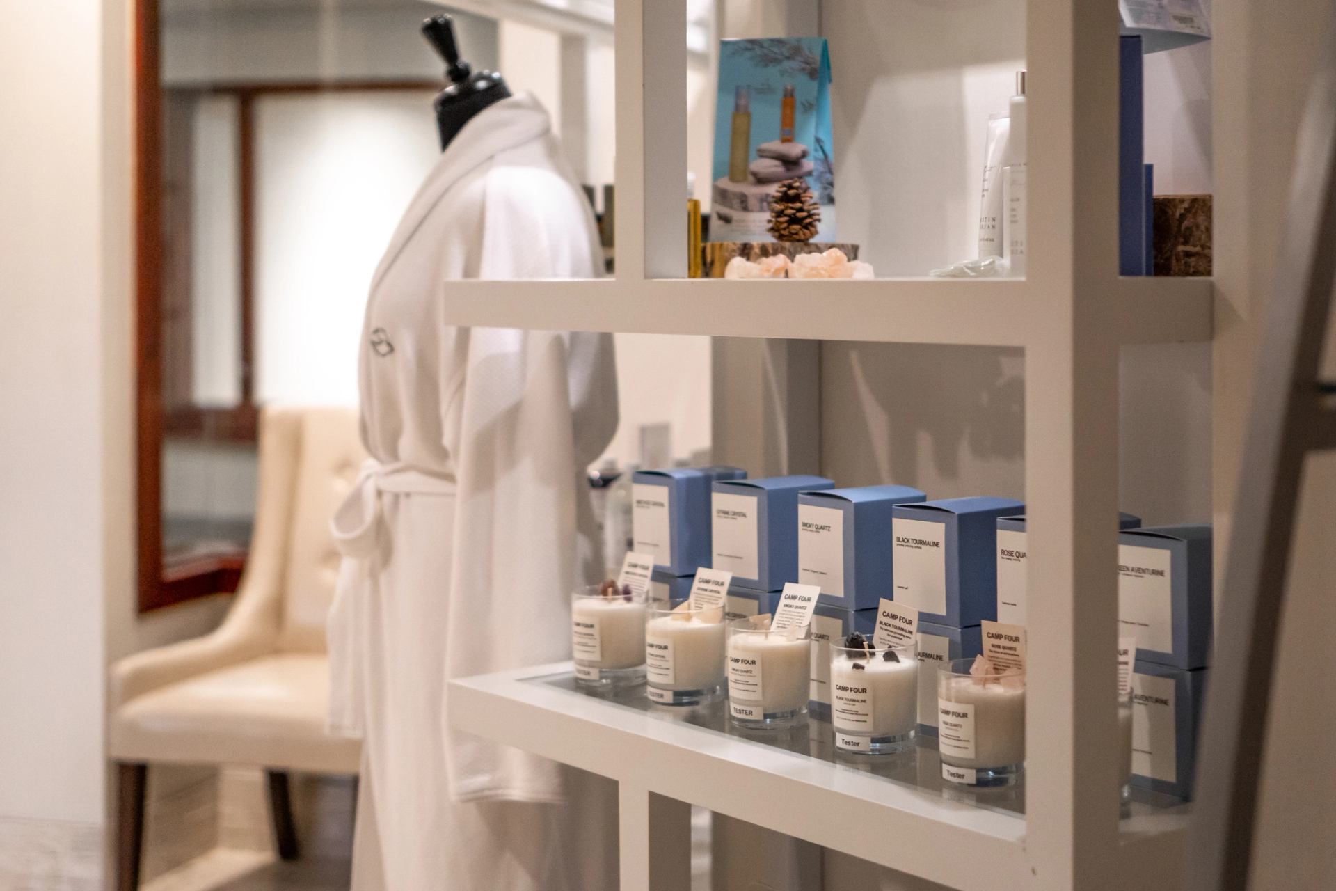Spa shelf with candles, boxes, and robed mannequin at Fairmont Jasper Spa.
