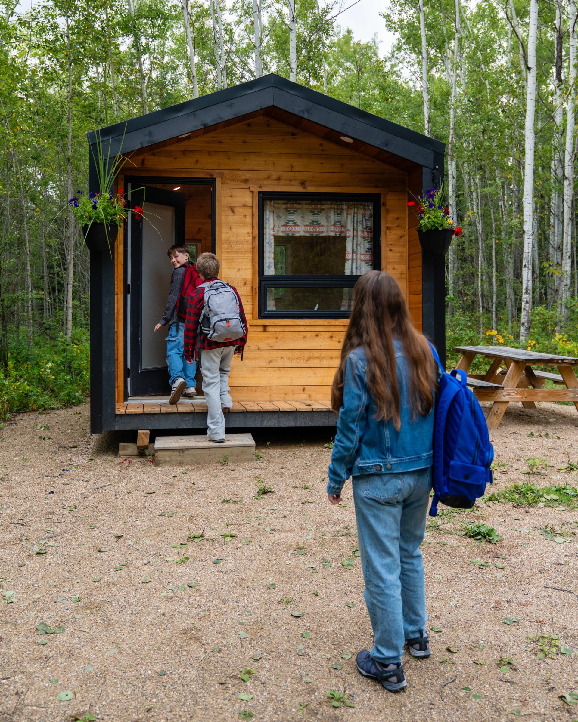 Youth entering a cabin with mom following.