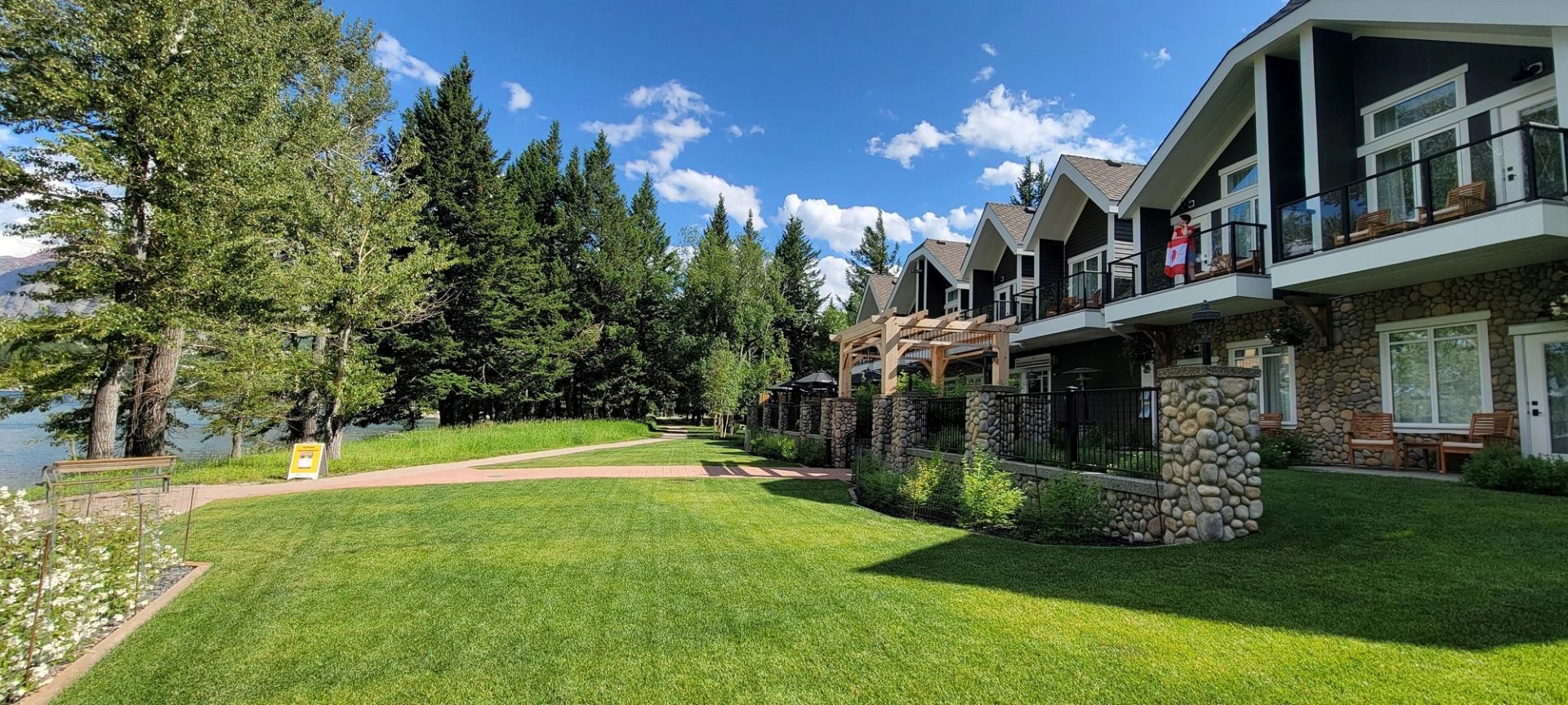 Kilmorey Lodge with balconies, green lawn, trees, and blue sky.