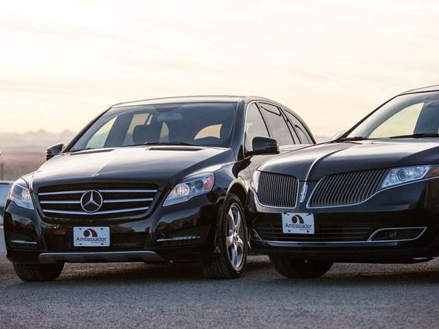 Black Mercedes and Lincoln with Ambassador Limousine Service plates, parked together.