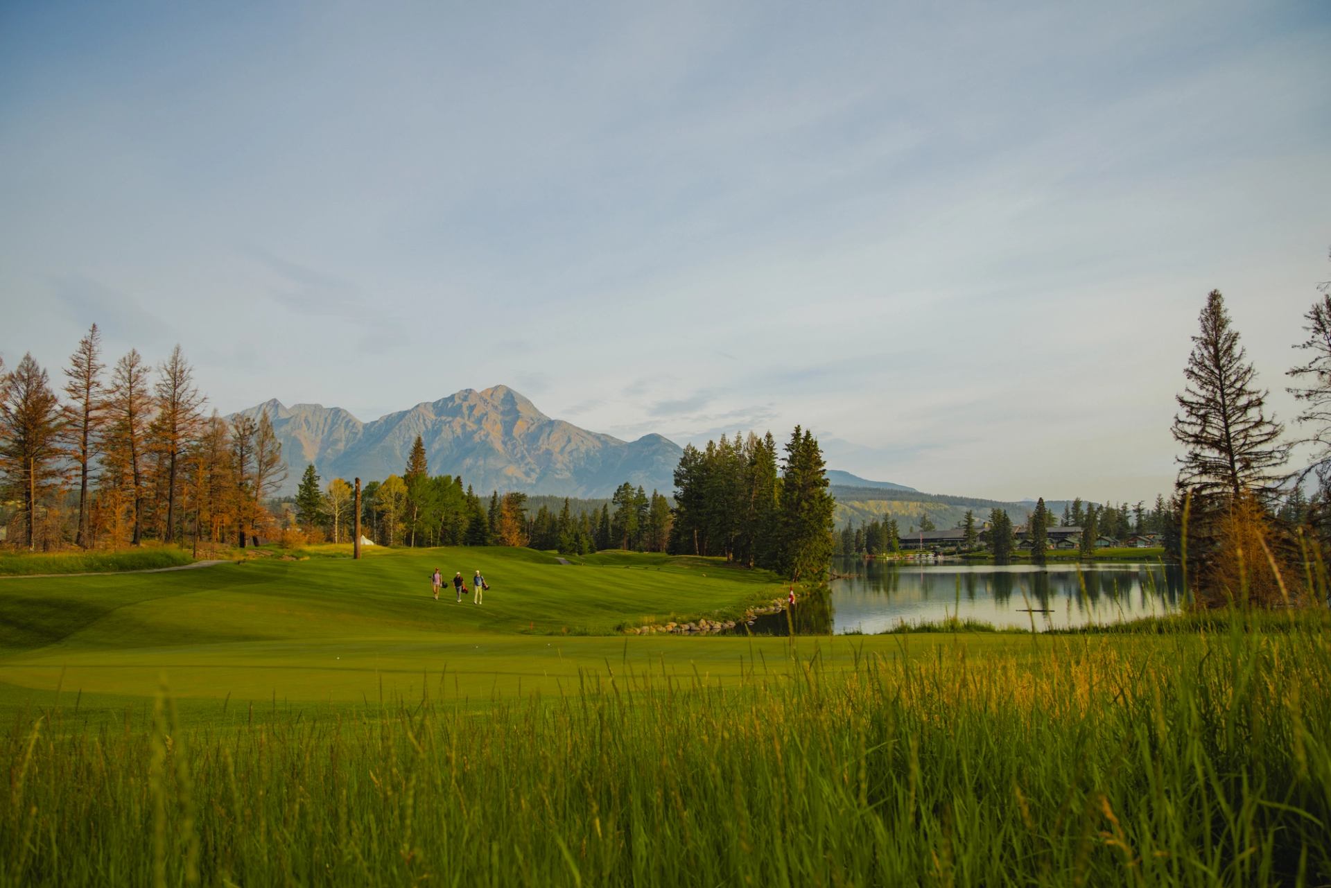 Group of golfers with a scenic view of Pyramid Mountain, Lac Beauvert and Fairmont Jasper Park Lodge