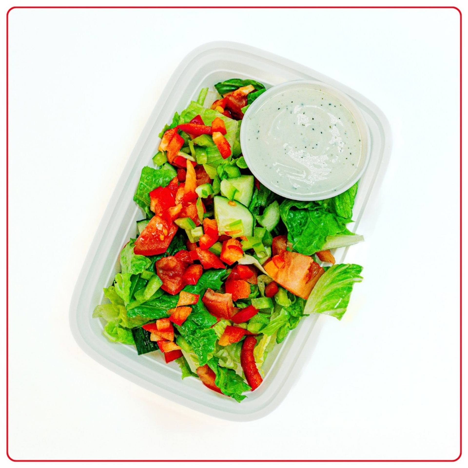 Crisp romaine lettuce, cucumbers, and peppers with a side of creamy dressing.