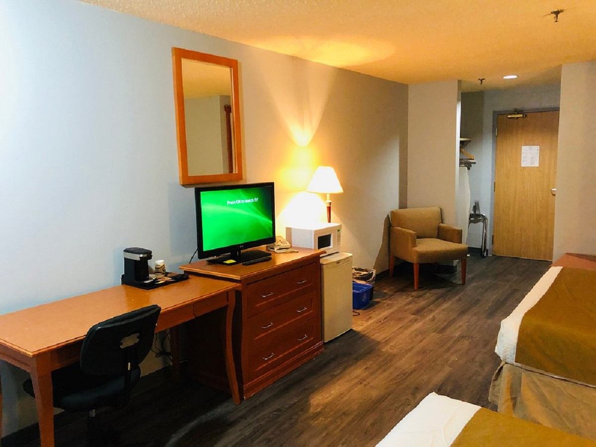 Hotel room with two beds, desk, TV, coffee maker, and microwave at Hotel Northern Star.