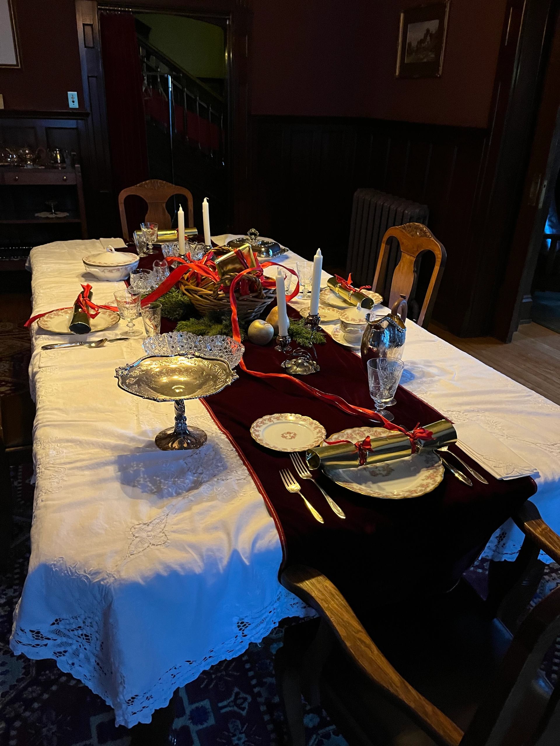 Elegant holiday table with candles, silverware, and festive décor at Rutherford House.
