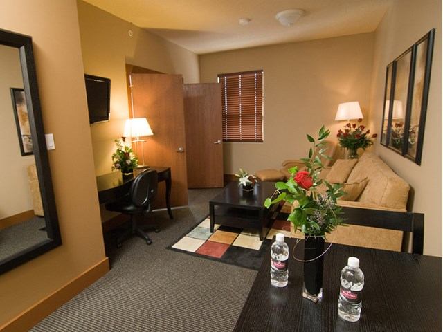 Cozy suite with sofa, desk, TV, and warm lighting at Podollan Inn and Spa.