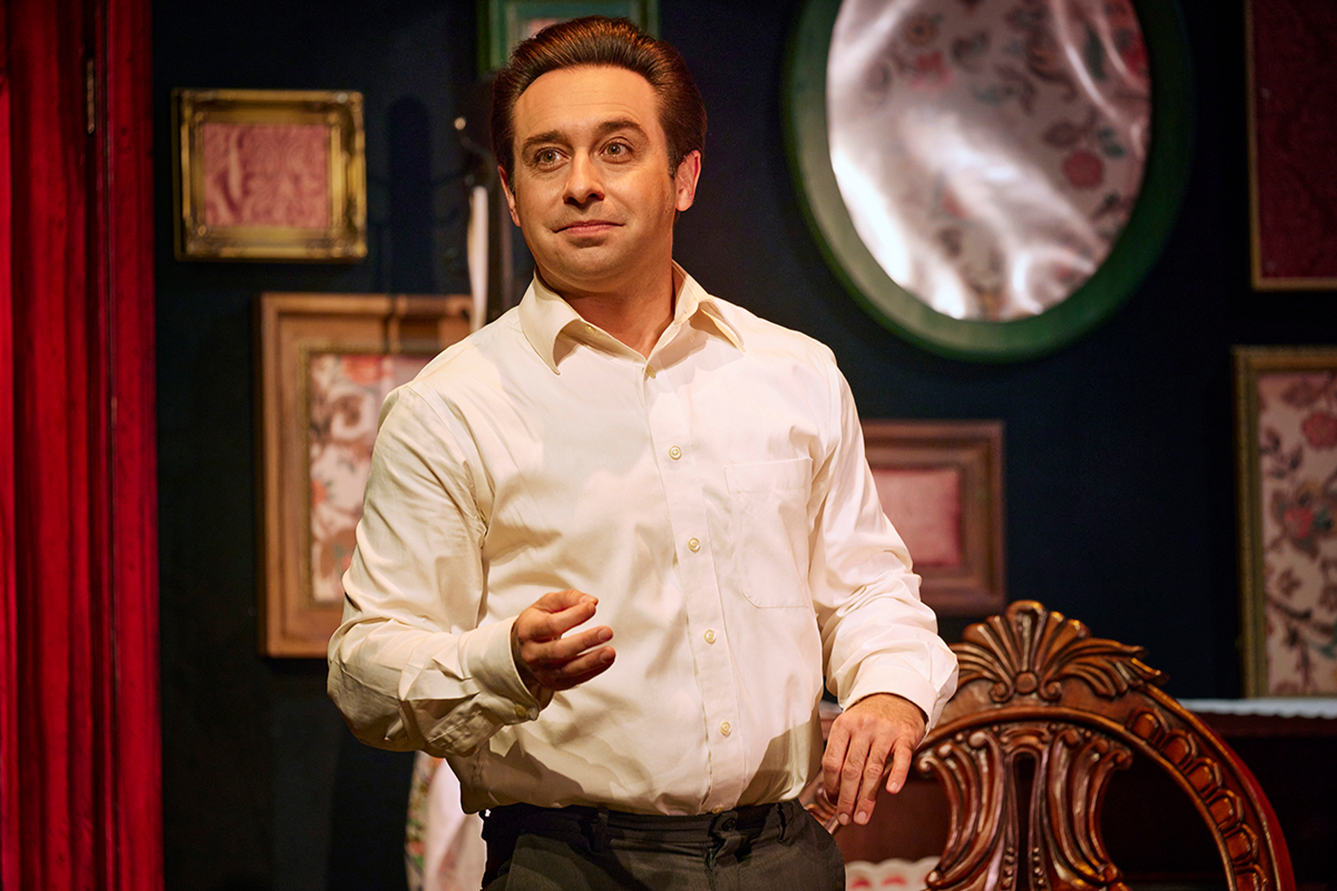 Farren Timoteo in Made in Italy, smiling and telling a story. Framed artwork in the background. 