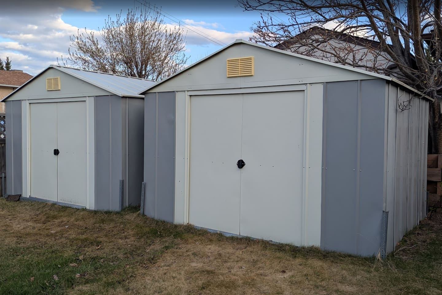 Two grey and white metal storage sheds.