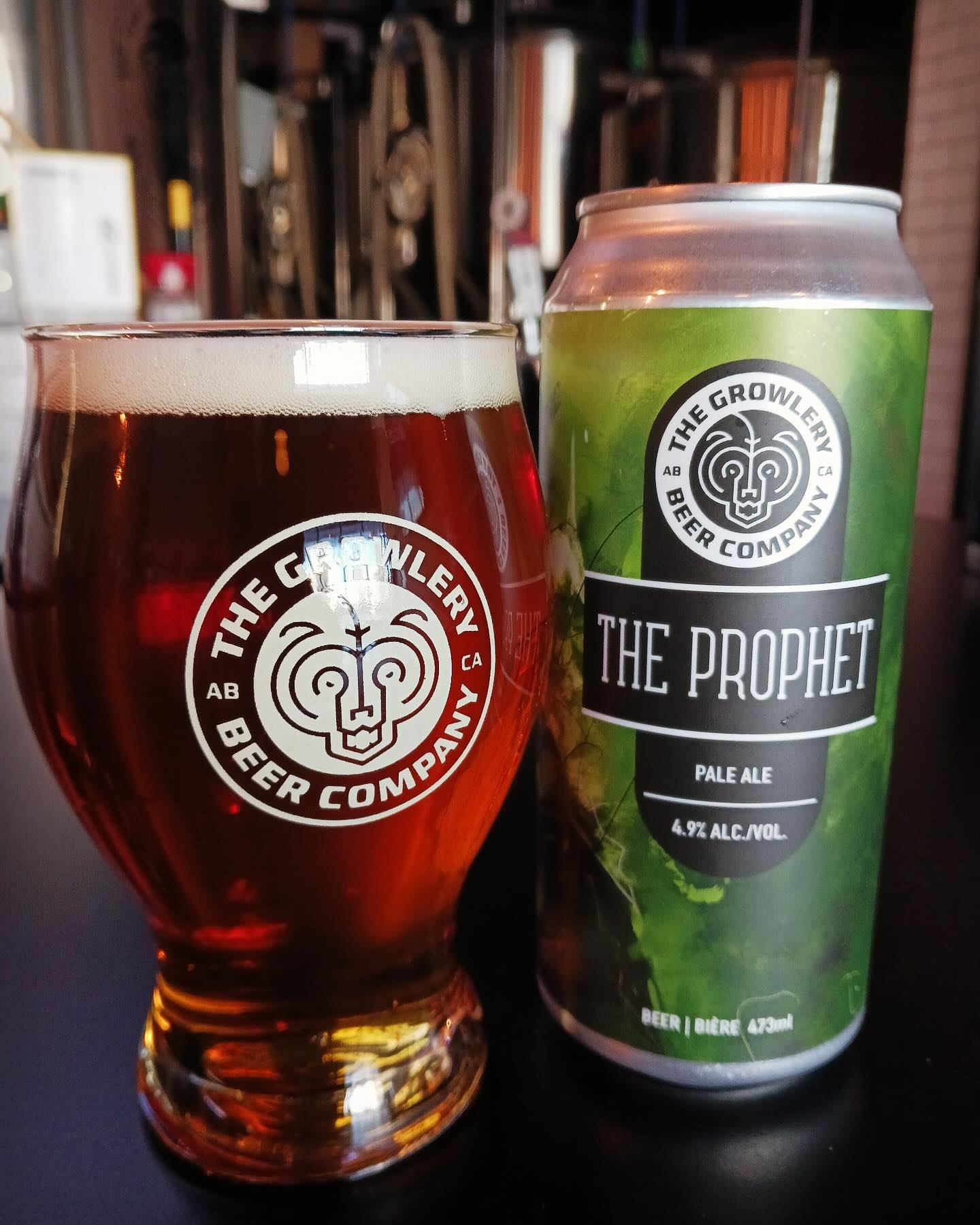 Pint of amber beer beside a can of The Prophet Pale Ale on the bar