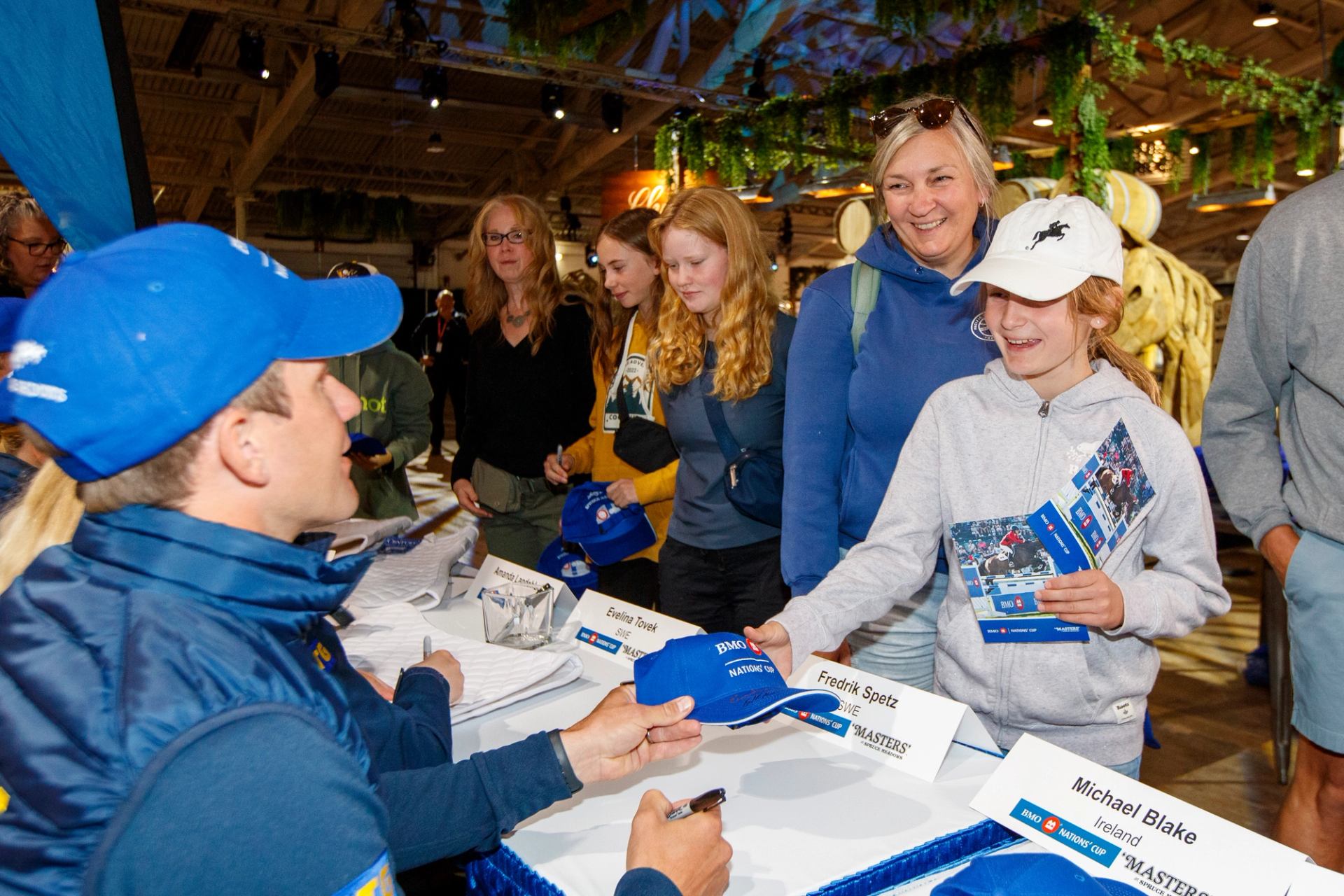 People gather at a table for autographs during the Spruce Meadows ‘Masters’ event.