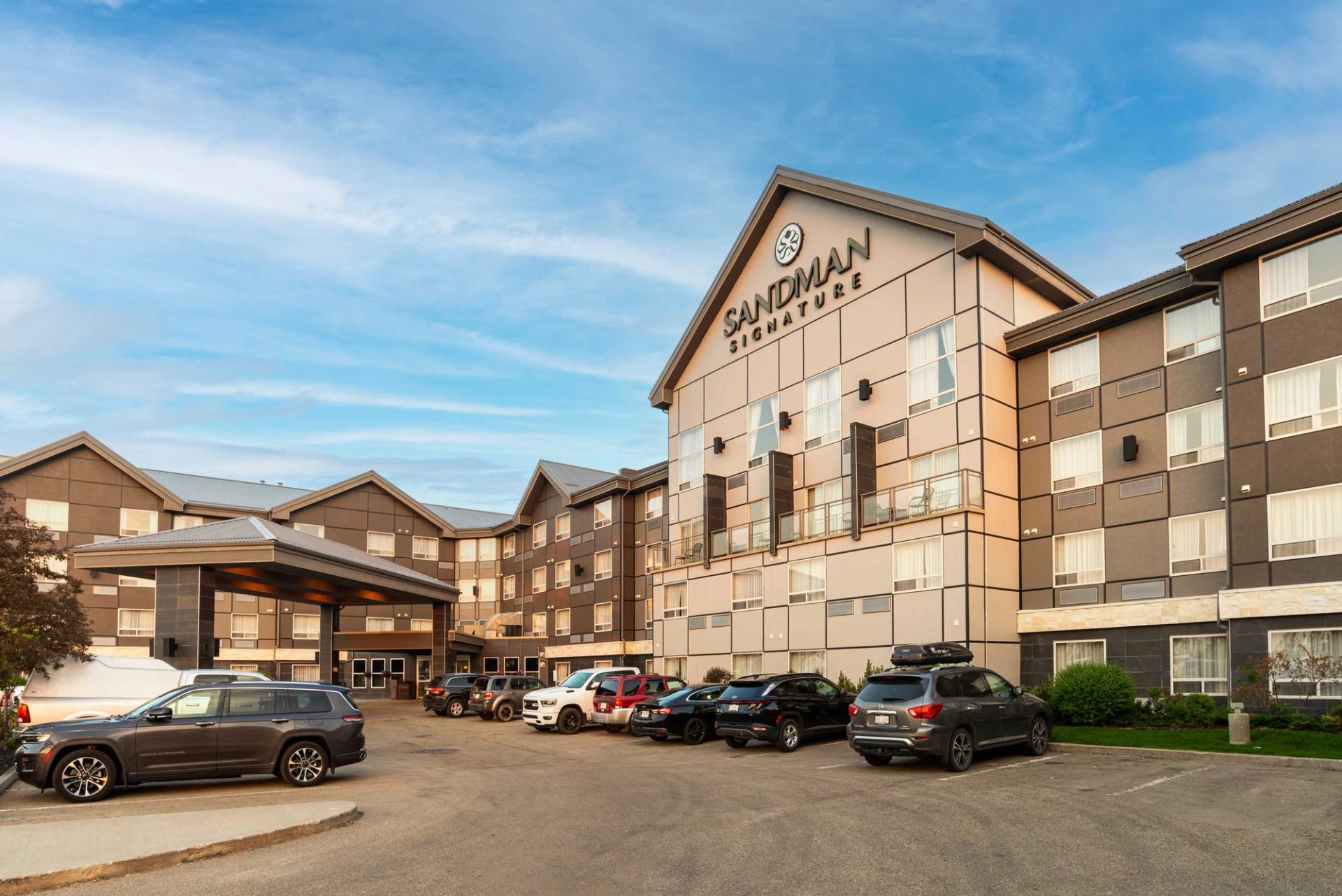 Exterior view of Sandman Signature Edmonton South Hotel with parking and main entrance.