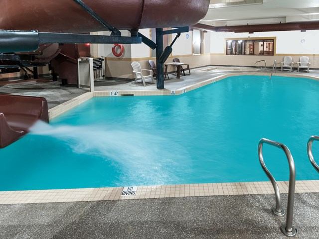 Indoor pool with slide and seating at Canalta Airdrie.
