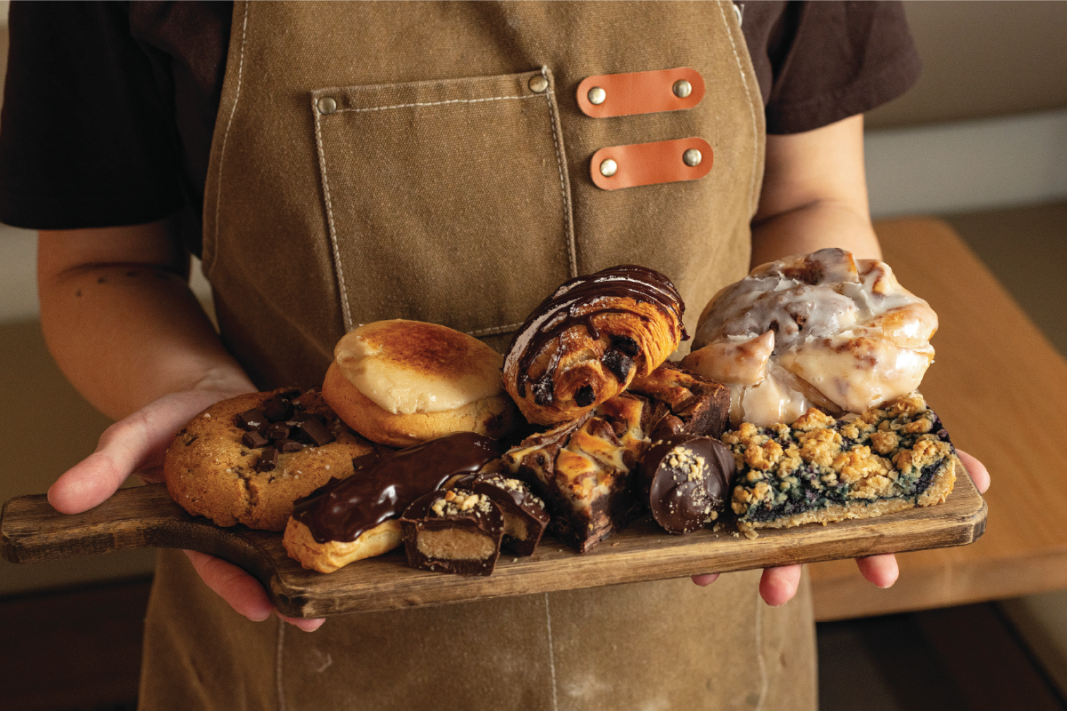 Tray of assorted pastries held by a person.