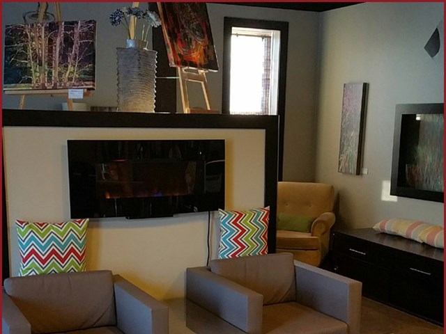 Art-filled lounge at Bean Brokers with cozy chairs and colorful pillows.