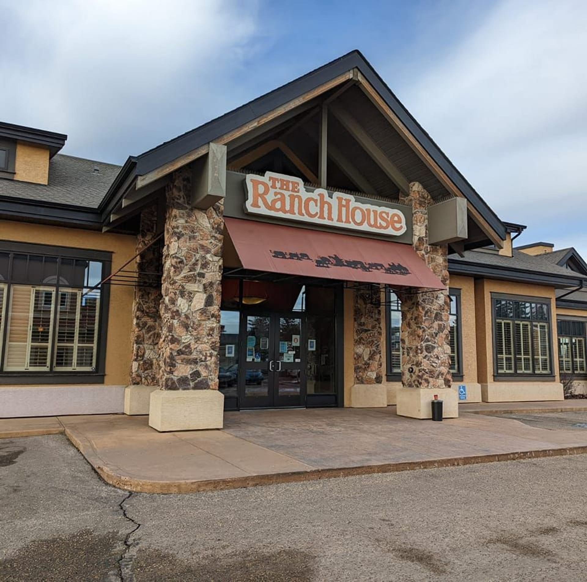 Stone-front restaurant entrance with red awning and sign