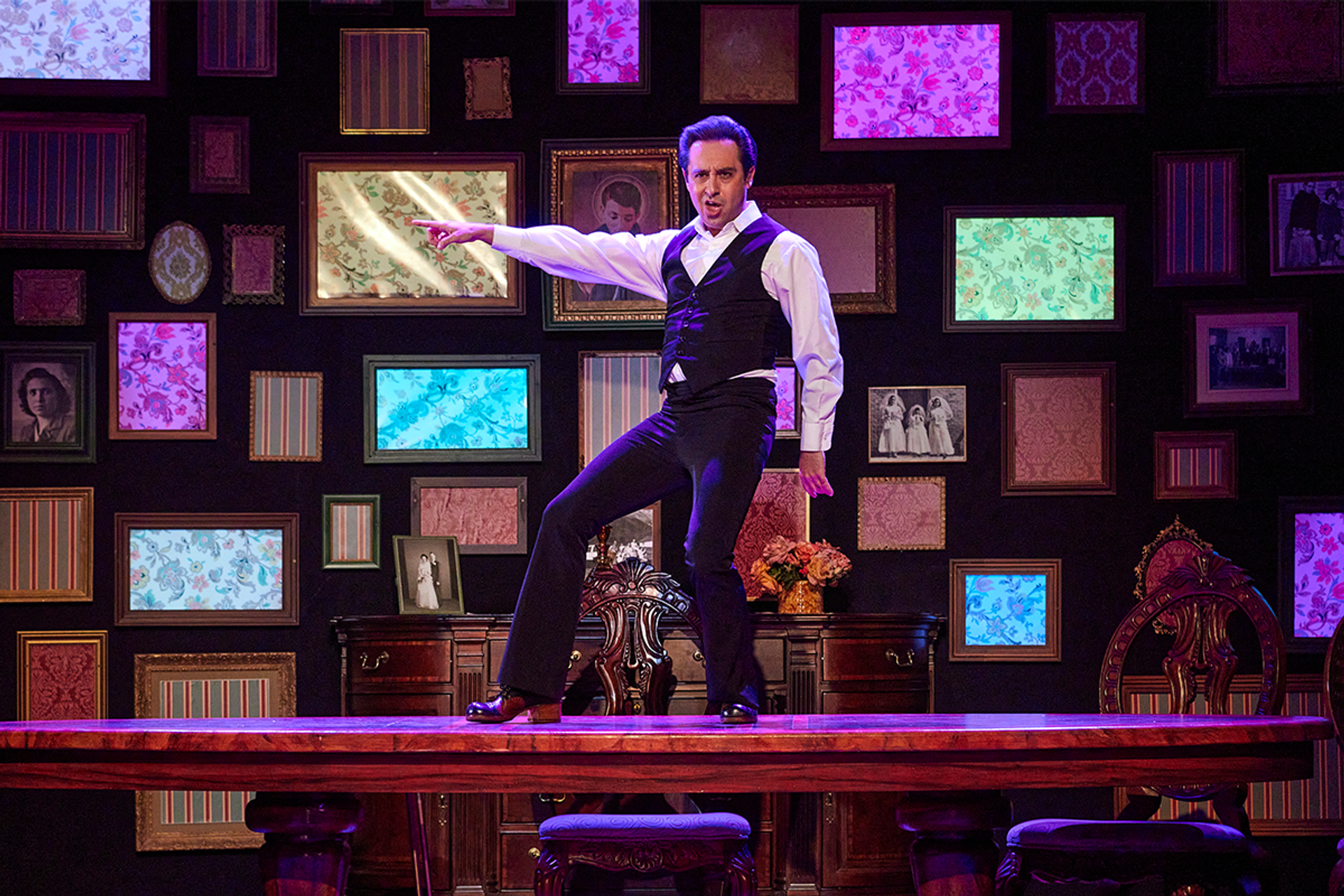 Farren Timoteo dances disco style, standing atop a dining room table, in Made in Italy. 