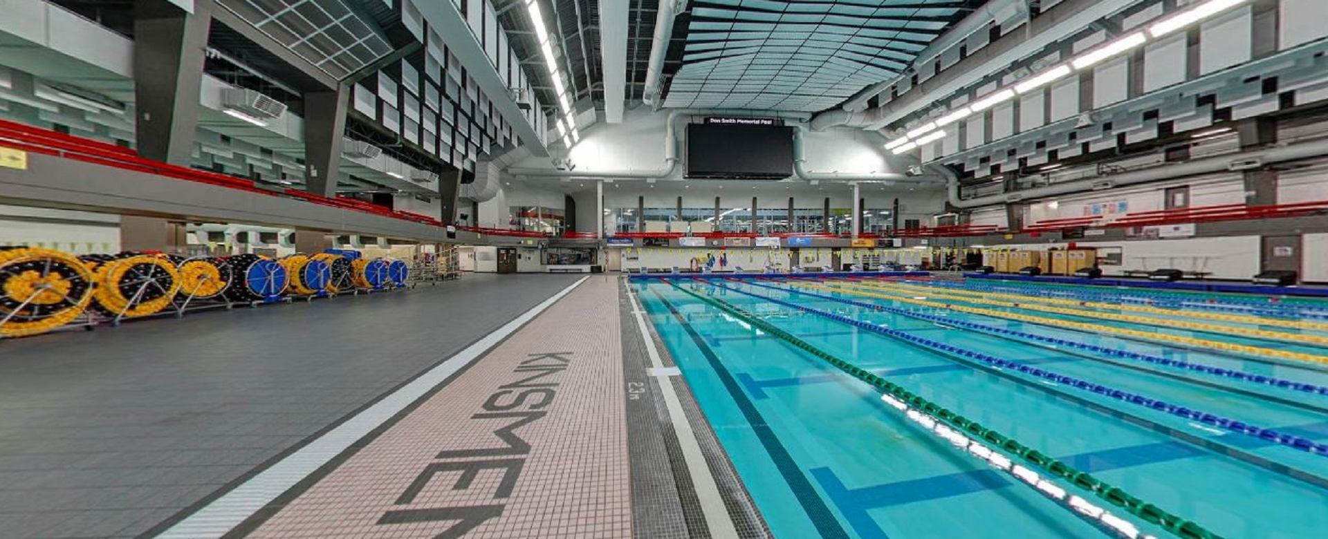 Indoor swimming pool with lane lines, starting blocks, and scoreboard at Kinsmen Sports Centre, Edmo.
