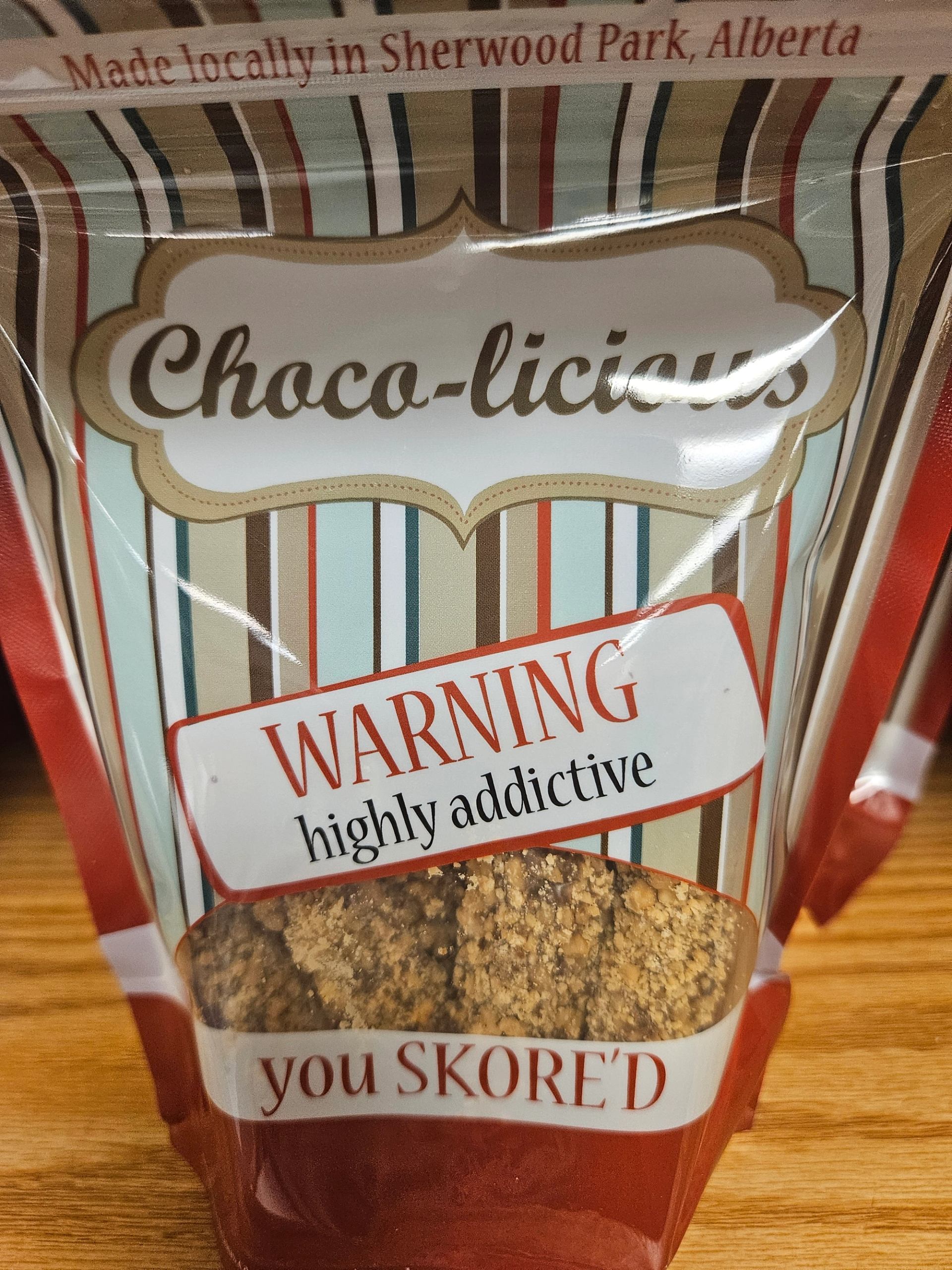 Choco-licious snack package with bold stripes and “WARNING highly addictive” label.