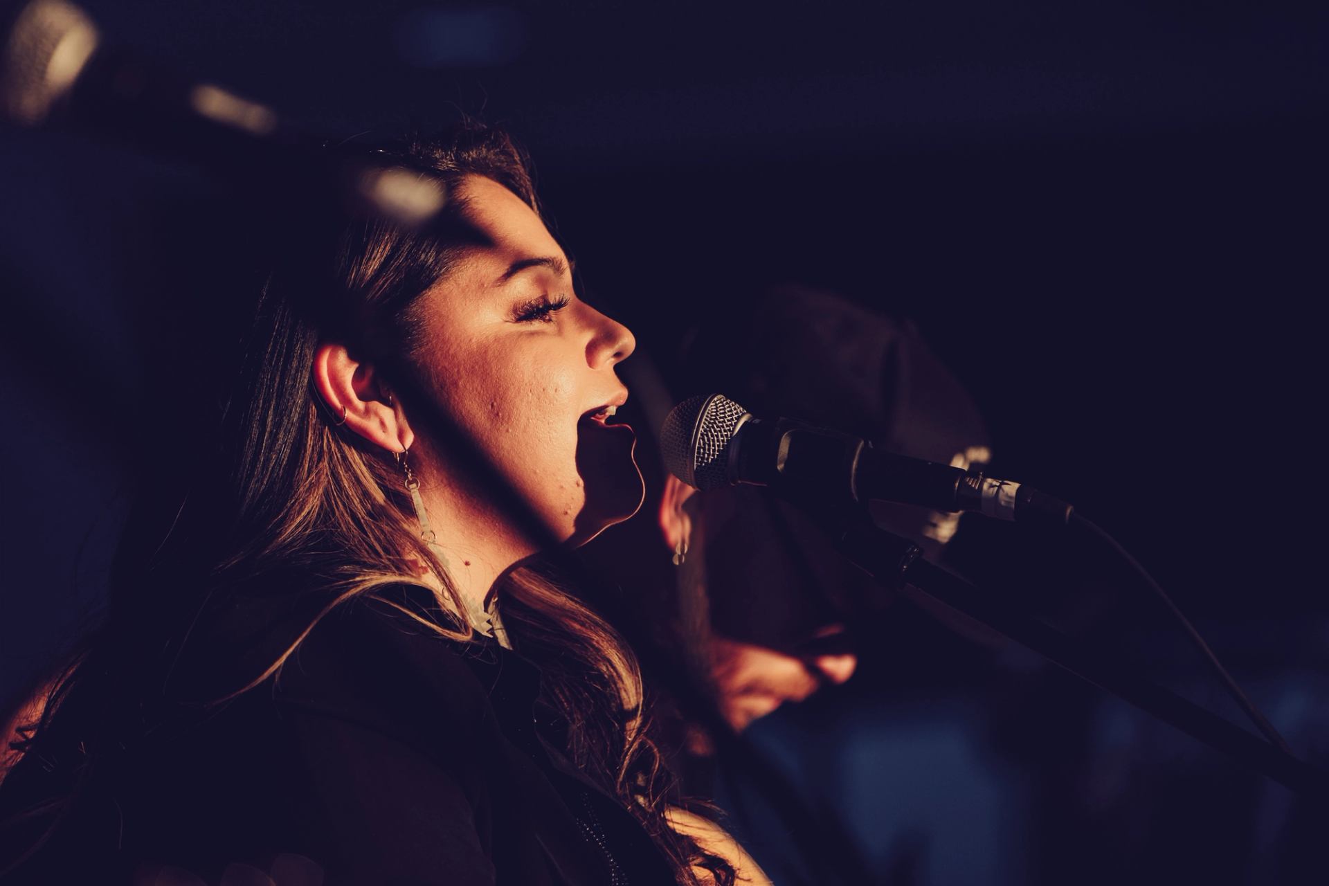 Two musicians performing under warm stage lights at Blue Jay Sessions.
