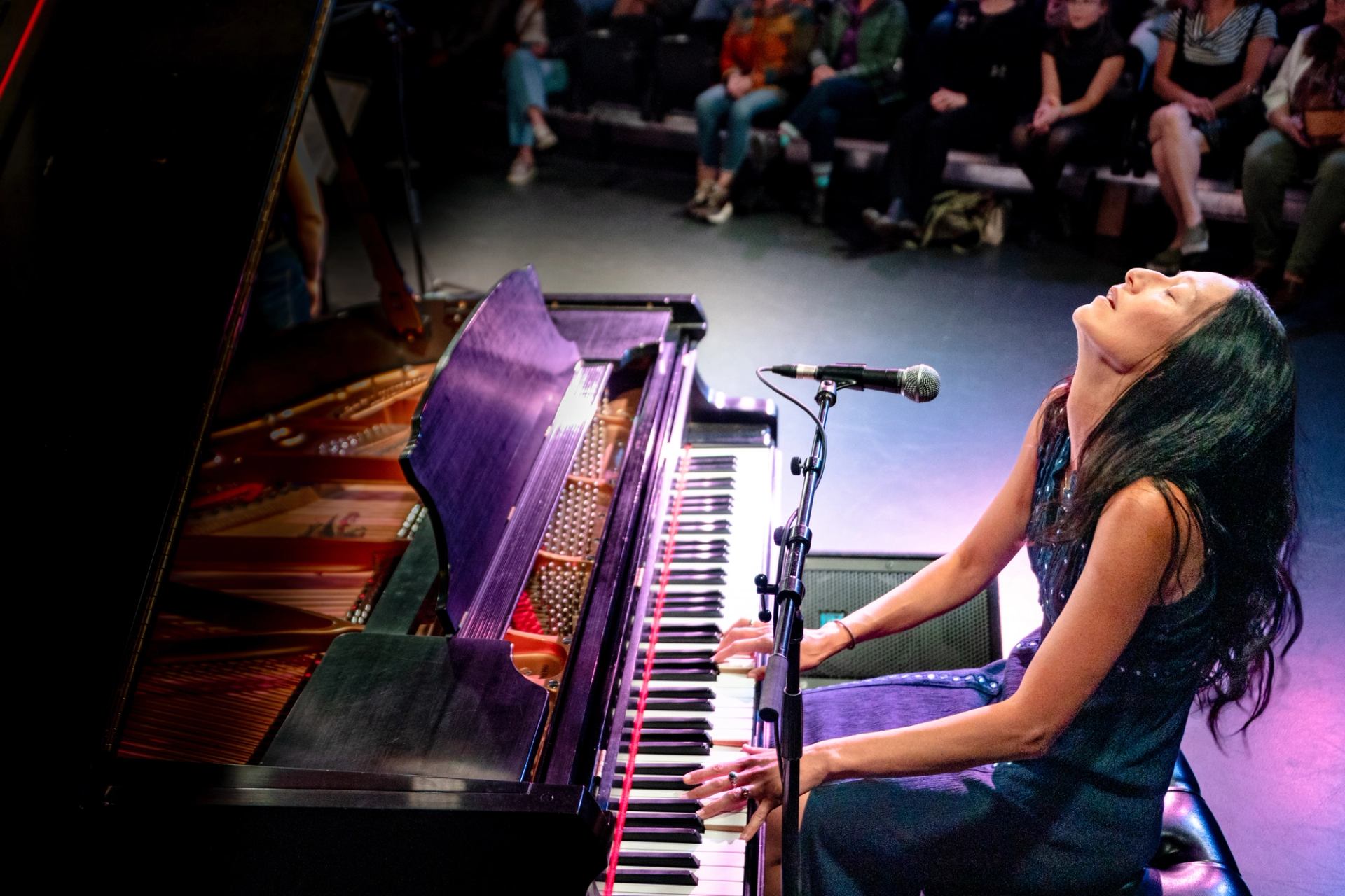 A woman sings while playing piano.